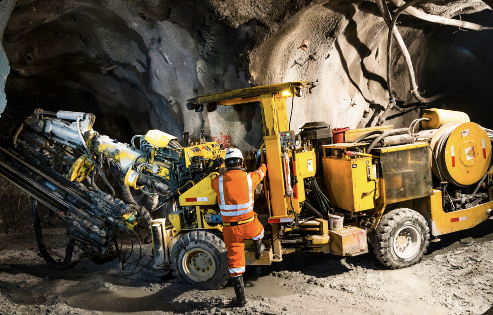 Underground mining operations with heavy drilling equipment and operator