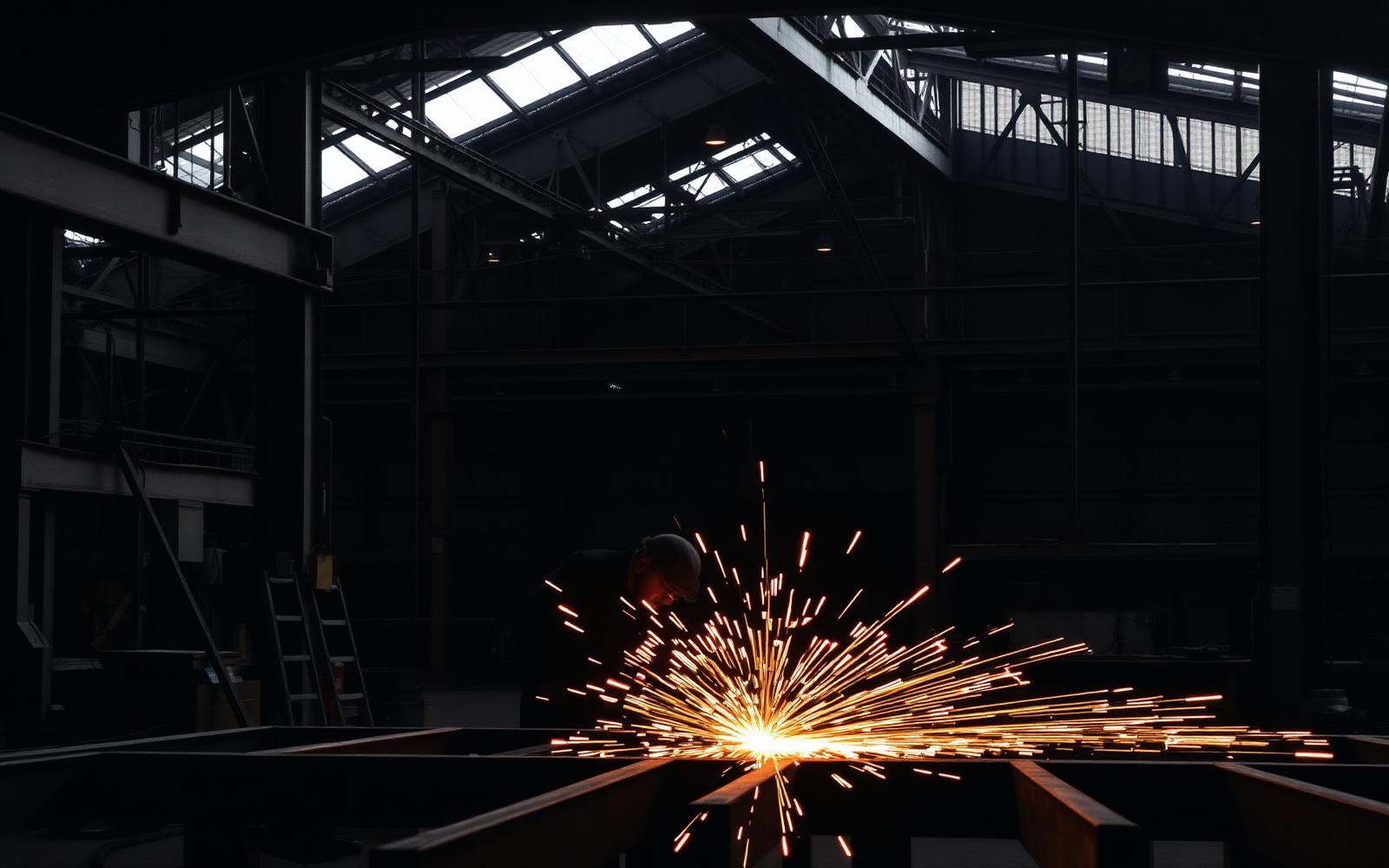 Welder fabricating structural steel in a workshop